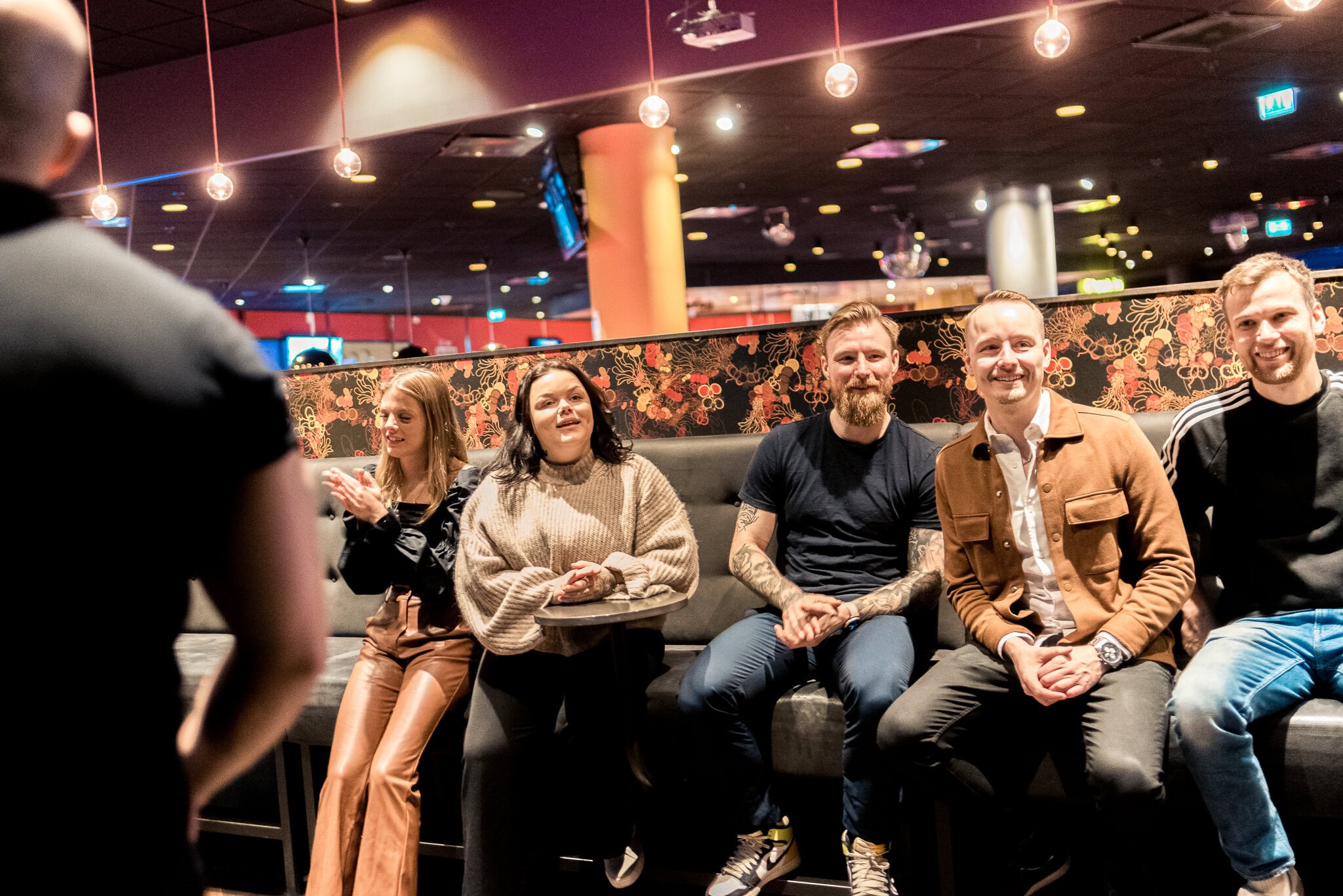 _DSC9204 Skrivande personer som spelar bowling på en bar eller nöjeslokal, skrattar och har roligt tillsammans.