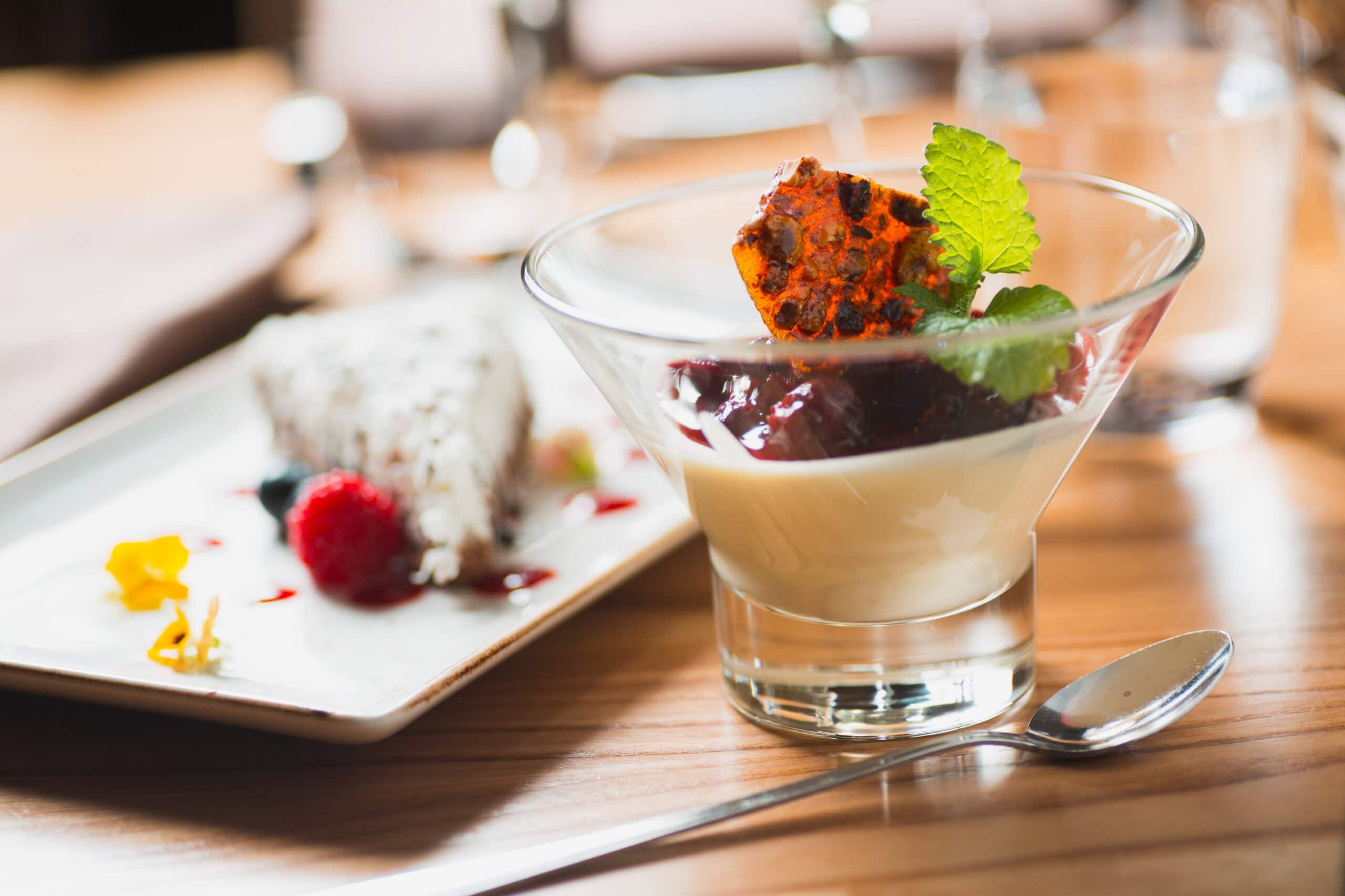 Delikat dessert med vaniljkräm, bär och mint tillagas på en restaurang eller bageri.