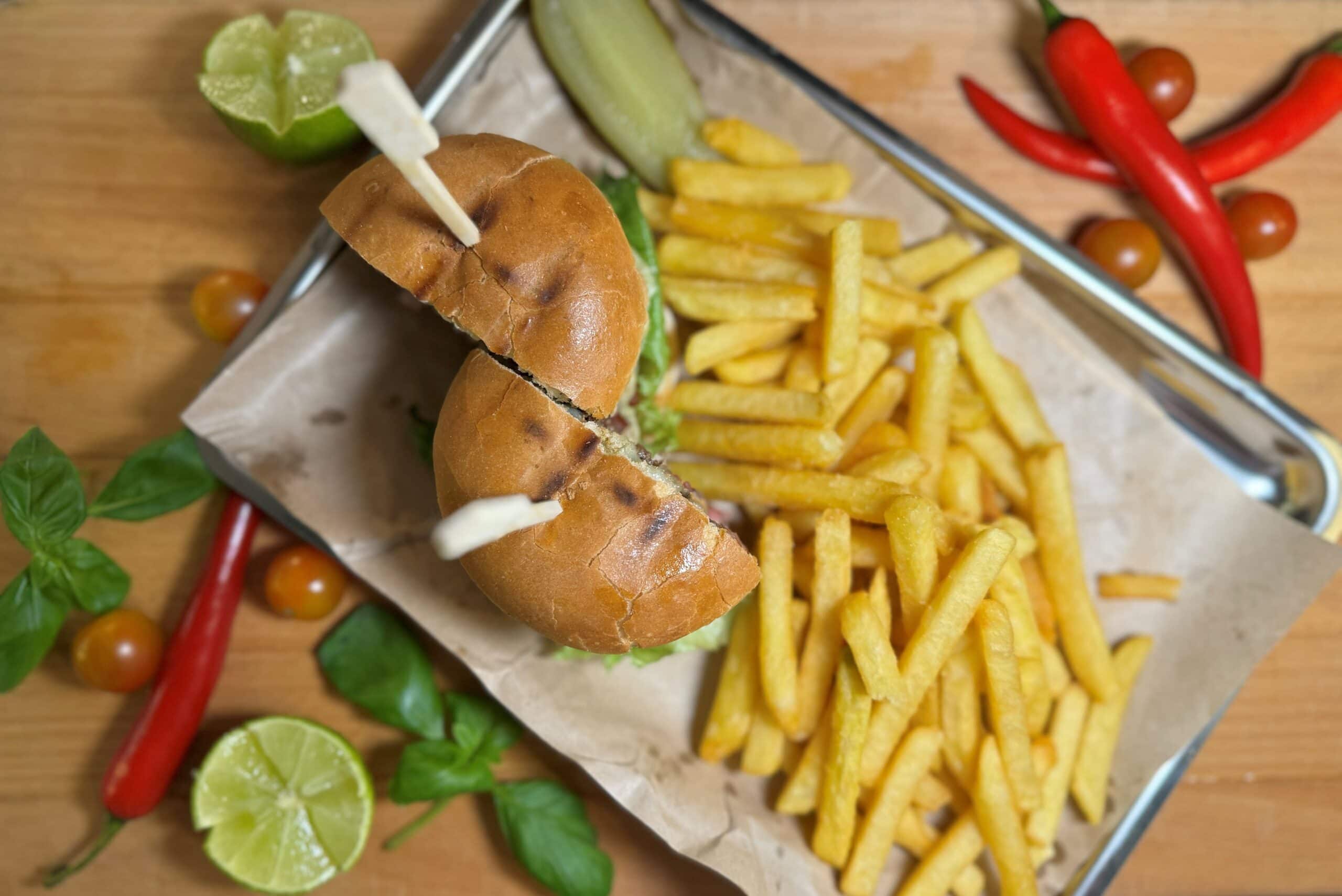 Ballbreakerburgare Färsk burrito med kyckling, grönsaker och pommes frites serverade i rostfri bricka. Enkel och utsökt maträtt perfekt för lunch eller middag, med frihet att anpassa tillbehör efter smak.