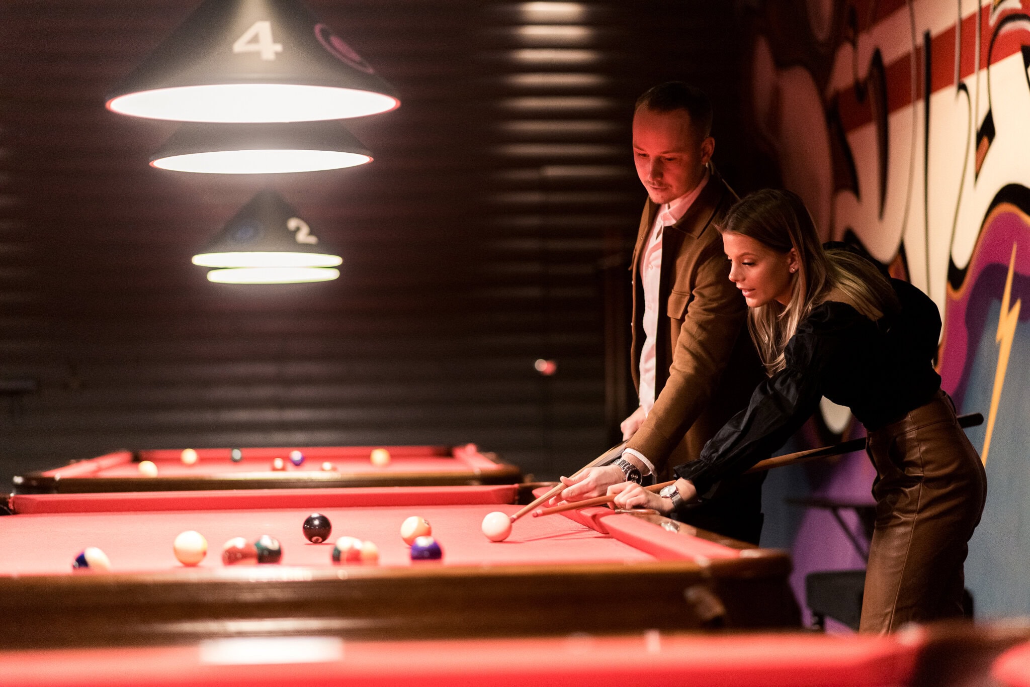 _DSC9443 Kvinna och man spelar biljard på en bar eller biljardhall.