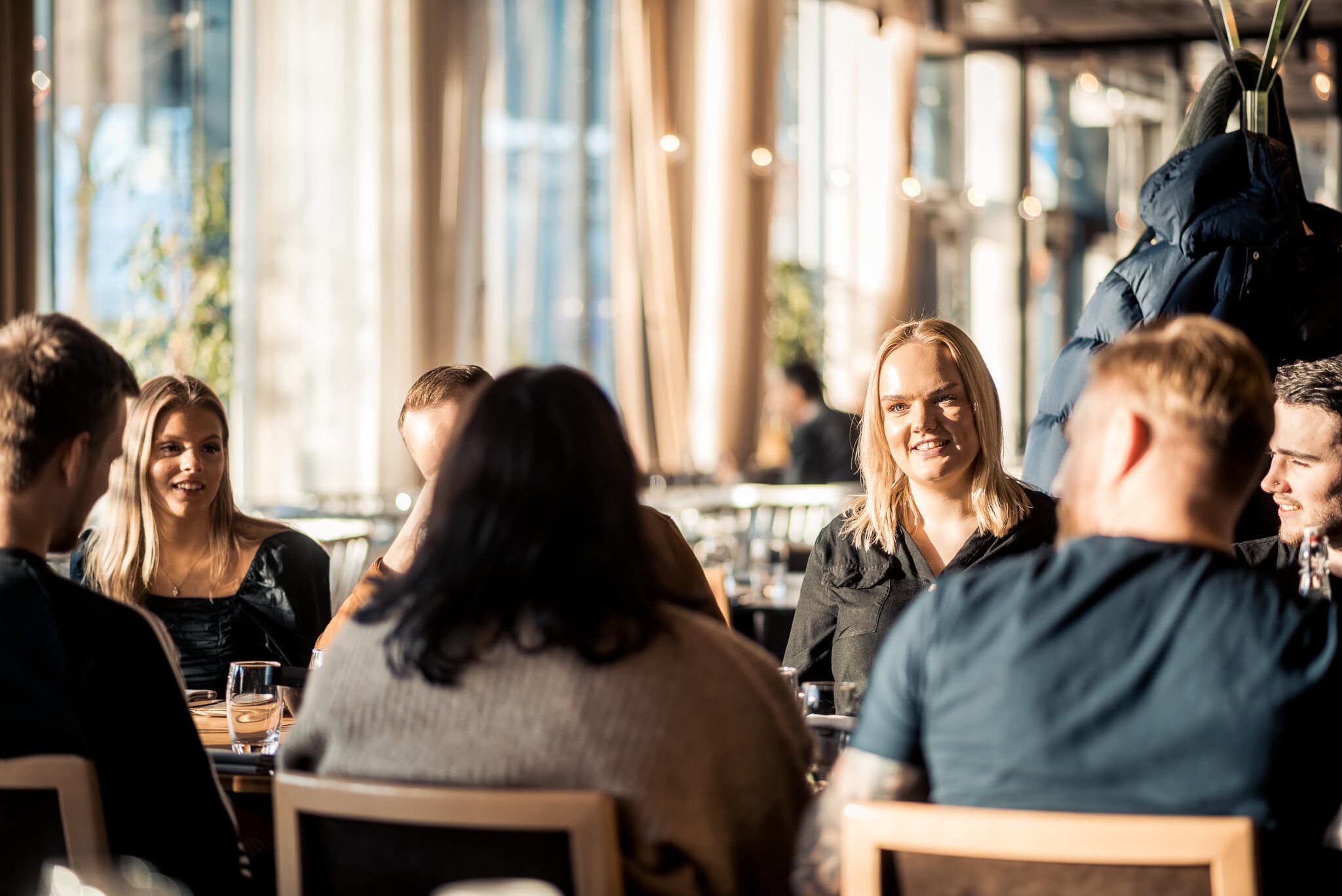 _DSC9532 Avslappnad social samling av unga vuxna i moderna lokaler, deltar i gemensamt spel eller diskussion, trevlig och livlig atmosfär, perfekt för nätverkande och vänskap.